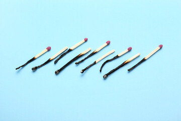 Row of burnt matches on color background. Concept of work burnout