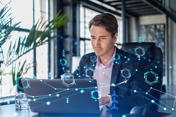 Handsome businessman in suit at workplace working with laptop to optimize development by implying...