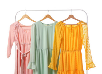 Rack with different trendy dresses on white background