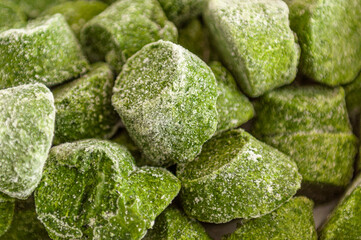 Green cubes of frozen spinach, close up image, used as background