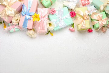 Beautiful spring composition with flowers and gift boxes on light background