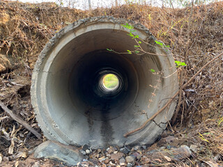 A concrete culvert that is under a road in the summer of the countryside, Image from mobile phone - obrazy, fototapety, plakaty