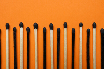 Different new matchsticks on orange background