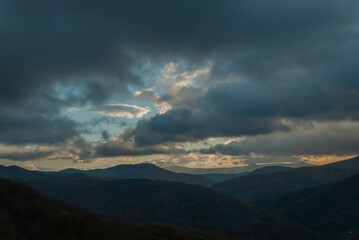 Mountainous landscape with a cloudy sunset sky