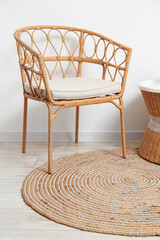 Comfortable wicker chair and stylish rug in room
