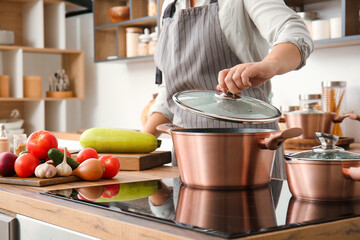 Woman with copper pot cooking in kitchen