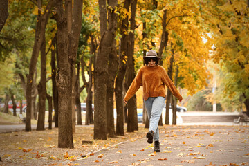 Young fashionable woman walking in autumn park