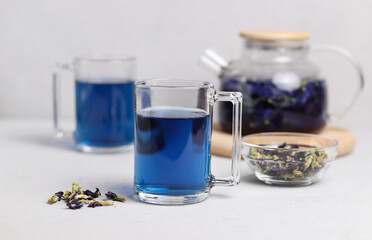 Organic fresh blue anchan tea in transparent glass cups on gray table.  Thai tea. Selective focus.