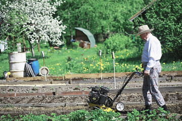 The farmer is digging a garden. The harvester plows the garden. The gray-haired grandfather mows the garden.