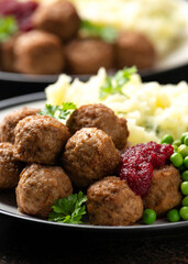 Homemade Swedish Meatballs with cranberry relish Sauce, potato mash and peas