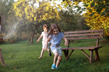 Obraz premium Children on a walk in the summer. Children indulge in the country. Laughter and splashing water.