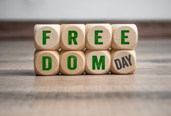 Cubes, dice or blocks with freedom day - metaphor for end of pandemic and endemic on wooden...