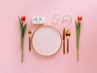 8 march table setting. Empty pink plate with gold cutlery, calendar with eight march date and red...