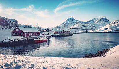 Winter nature scenery. Lofoten islands. Norway. Wonderful nature of north. View on fjord, fishing huts and snowcovered mountais during sunset. Best travel locations for travel in the world
