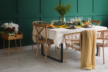Dining table with beautiful setting near green wall