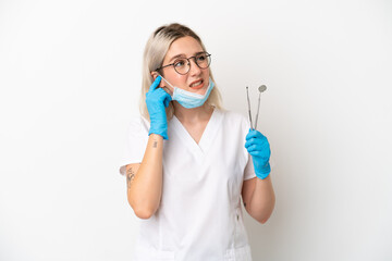 Dentist caucasian woman holding tools isolated on white background frustrated and covering ears