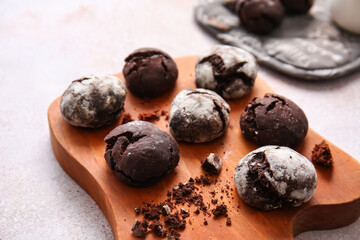 Wooden board of chocolate brownie cookies on light background, closeup