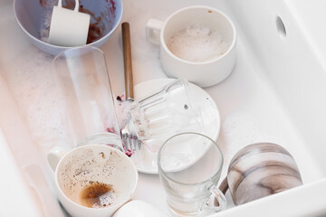 Dirty dishes in ceramic sink, closeup