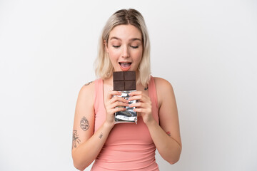 Young caucasian woman isolated on white background eating a chocolate tablet