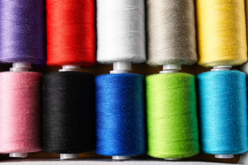 Spools with sewing threads as background, closeup
