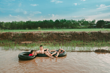 Kids playing and swimming in canal of organic farm in countryside 