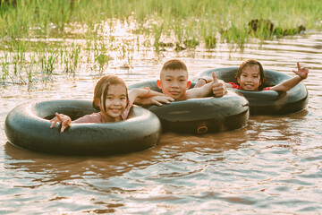 Kids playing and swimming in canal of organic farm in countryside 