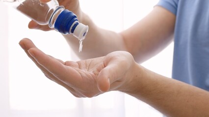 Obraz premium A sanitizer is poured onto the hand to treat infections, to prevent the spread of coronavirus infection. Treat hands with disinfectants. Disinfection of the skin of the hands.