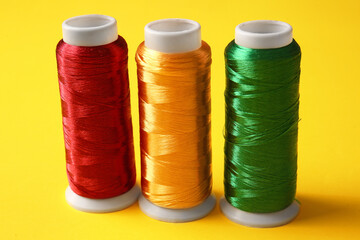 Thread spools on yellow background, closeup
