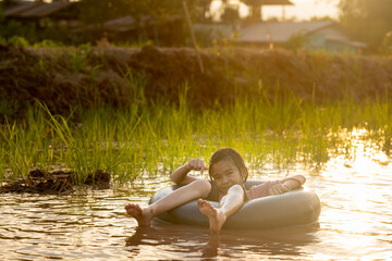 Kids playing and swimming in canal of organic farm in countryside 