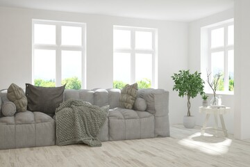 Minimalist living room in white color with sofa and summer landscape in window. Scandinavian interior design. 3D illustration