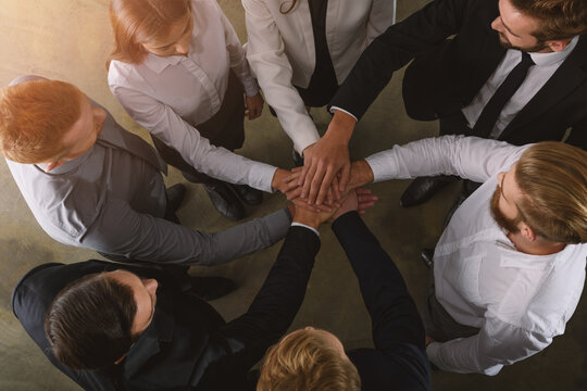 Business people putting their hands together as teamwork and partner