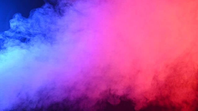 Puffs of colored pink-blue smoke on a black background,.