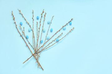 Easter eggs and pussy willow branches on blue background