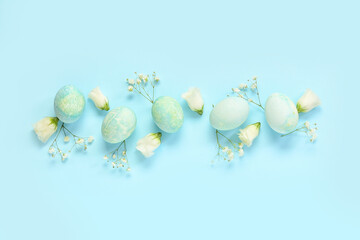 Composition with Easter eggs and flowers on blue background