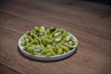 diced kiwifruit in a white bowl on a wooden table