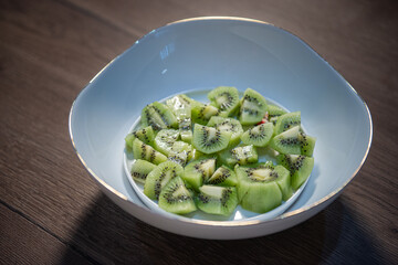 diced kiwifruit in a white bowl on a wooden table