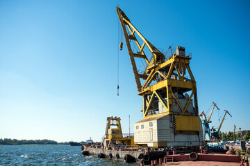 Fototapeta na wymiar Floating crane moored at the shipyard