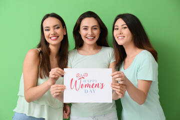 Beautiful women holding paper with text HAPPY WOMEN'S DAY on green background