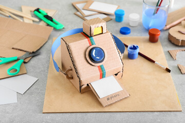 Handmade cardboard photo camera on table