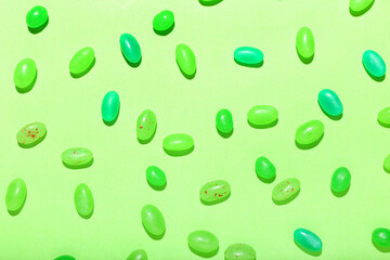 Different jelly beans on green background