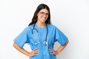 Young surgeon doctor caucasian woman isolated on white background posing with arms at hip and smiling
