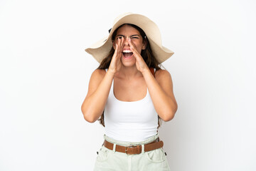 Young caucasian woman wearing a Pamela in summer holidays isolated on white background shouting and...