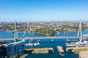 Aerial drone view of Anzac Bridge across Johnstons Bay looking toward Rozelle Bay and Bicentennial Park in Rozelle, Sydney, Australia on a sunny morning