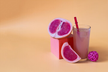 Grapefruit juice, decor and grapefruit slices on an orange background close-up.