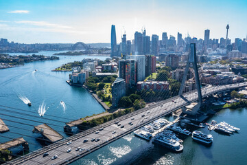 Aerial drone view of Anzac Bridge looking toward Sydney City and Sydney Harbour on a sunny morning