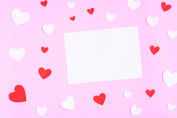 White greeting card with heart papercut on pink background