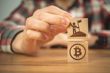 Business successful with bitcoin. Concept of investment and success. Wooden cubes with BTC and businessman icon close-up photo