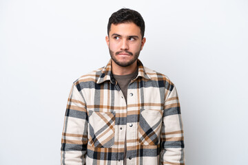 Fototapeta premium Young Brazilian man isolated on white background having doubts while looking up