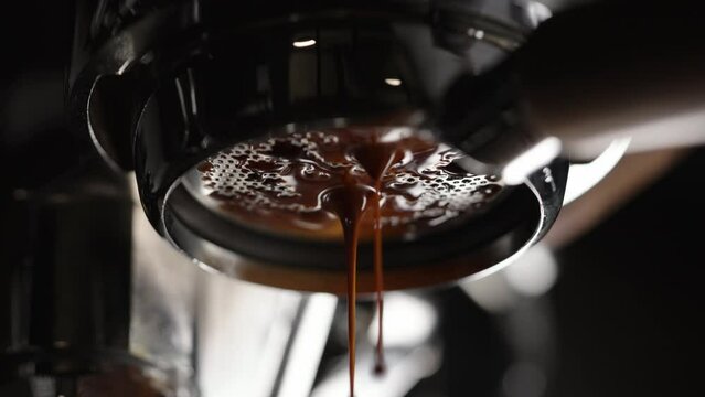 Slow motion closeup shot of espresso extraction with bottomless portafilter
