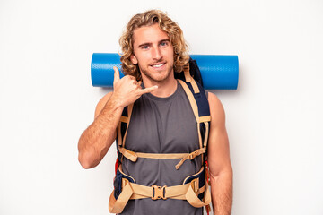 Young mountaineer caucasian man with a big backpack isolated on white background showing a mobile phone call gesture with fingers.